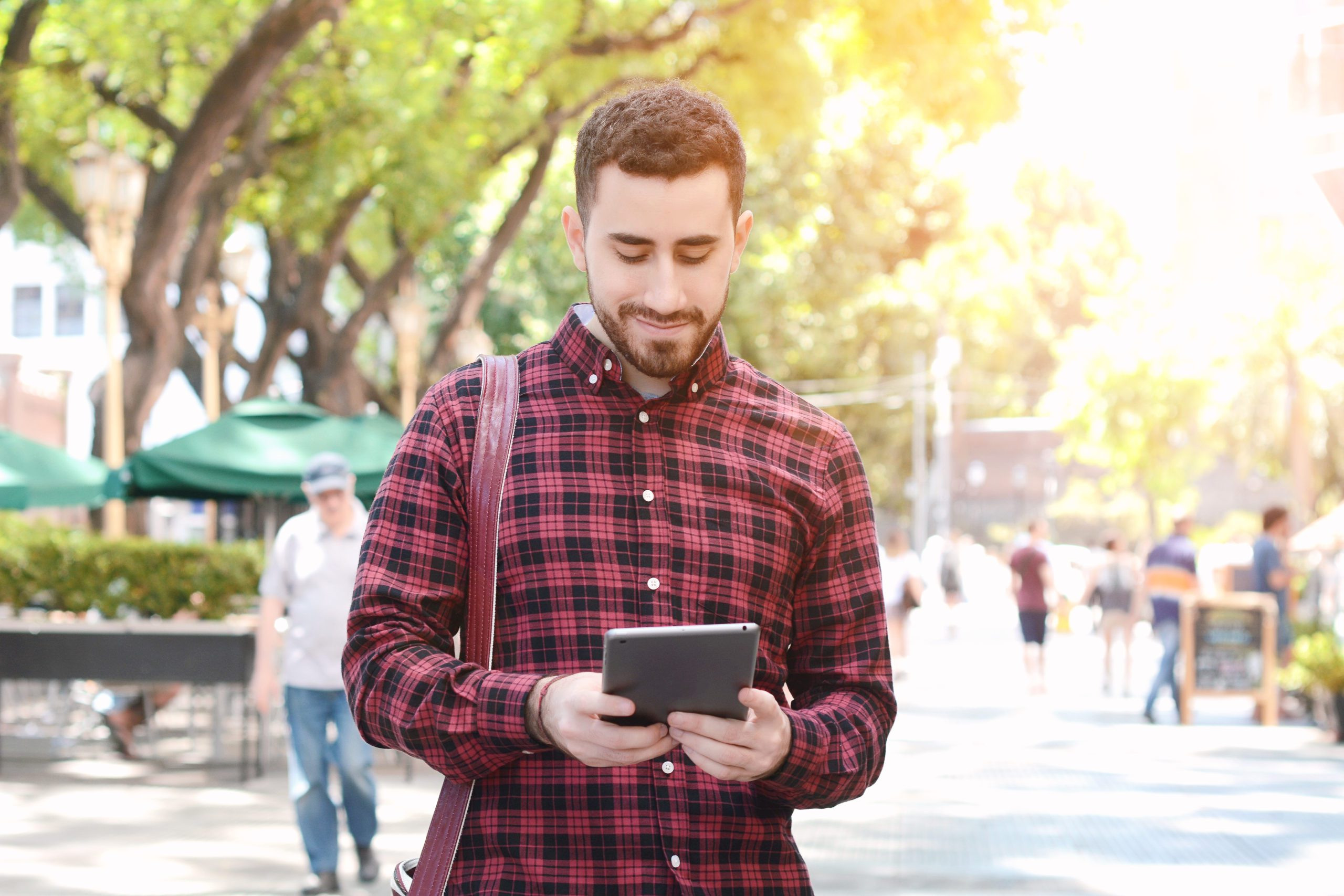 Young Latin Man Using A Tablet Young latin man using a tablet. Urban scene